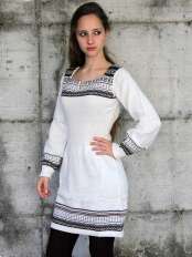 Mujer con vestido corto de alpaca blanco, motivo jacquard negro, beige y gris en el bajo y las mangas, modelo Giuditta.