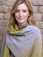 Nahaufnahme einer blonden Frau mit eleganter Ruana aus Baby-Alpaka, Modell Pampa.